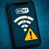 ESETロゴ付きスマートフォン画面に、割れたWi-Fiアイコンと黄色い警告マークが表示され、青い回路基板背景で接続トラブルを表現