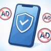 アニメ風タッチで描かれた青いスマートフォンの画面に盾アイコン、周囲に「AD」禁止マークが浮かぶ広告ブロックのイメージ