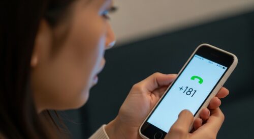 不安な表情の女性が、スマートフォンに表示された「181」と「+181」の不審な着信番号を見つめている画像。