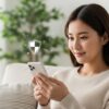 ソファでスマートフォンを操作し、ネットショッピングを楽しむ20代の日本人女性。PLUGアプリの危険性について調べて安心し、お得な情報を見つけて満足げな表情を浮かべている様子。スマホの周りにはセキュリティを象徴するアイコンが浮かんでいる。